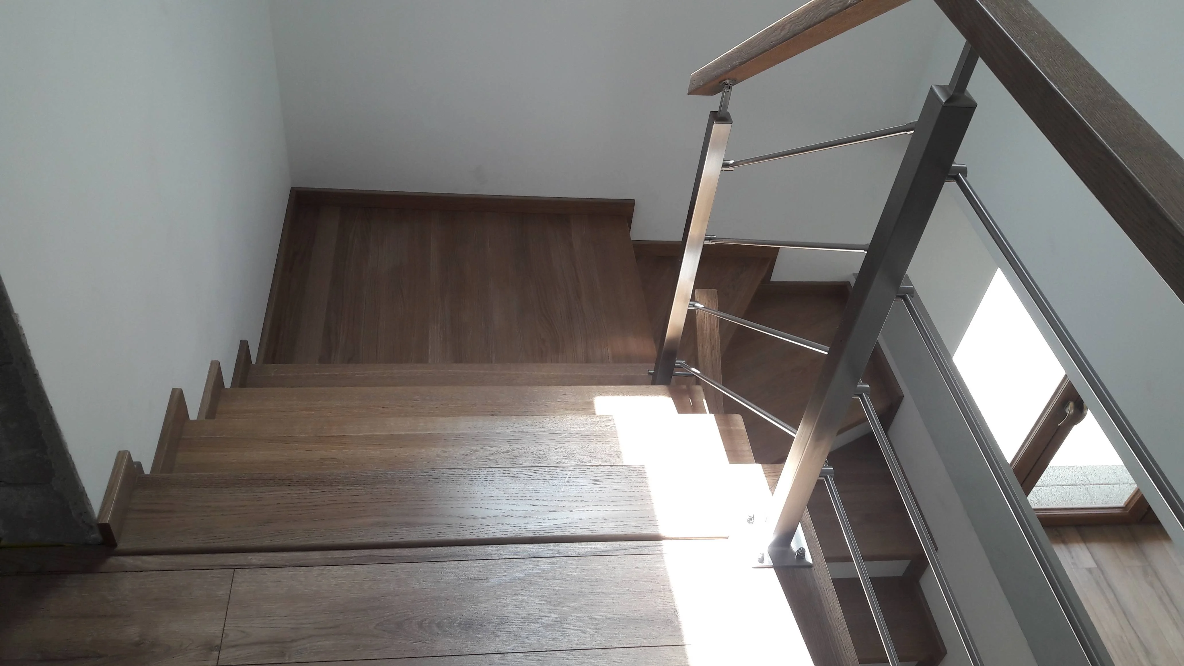 Widok schodów z góry, kontrast drewna i bieli