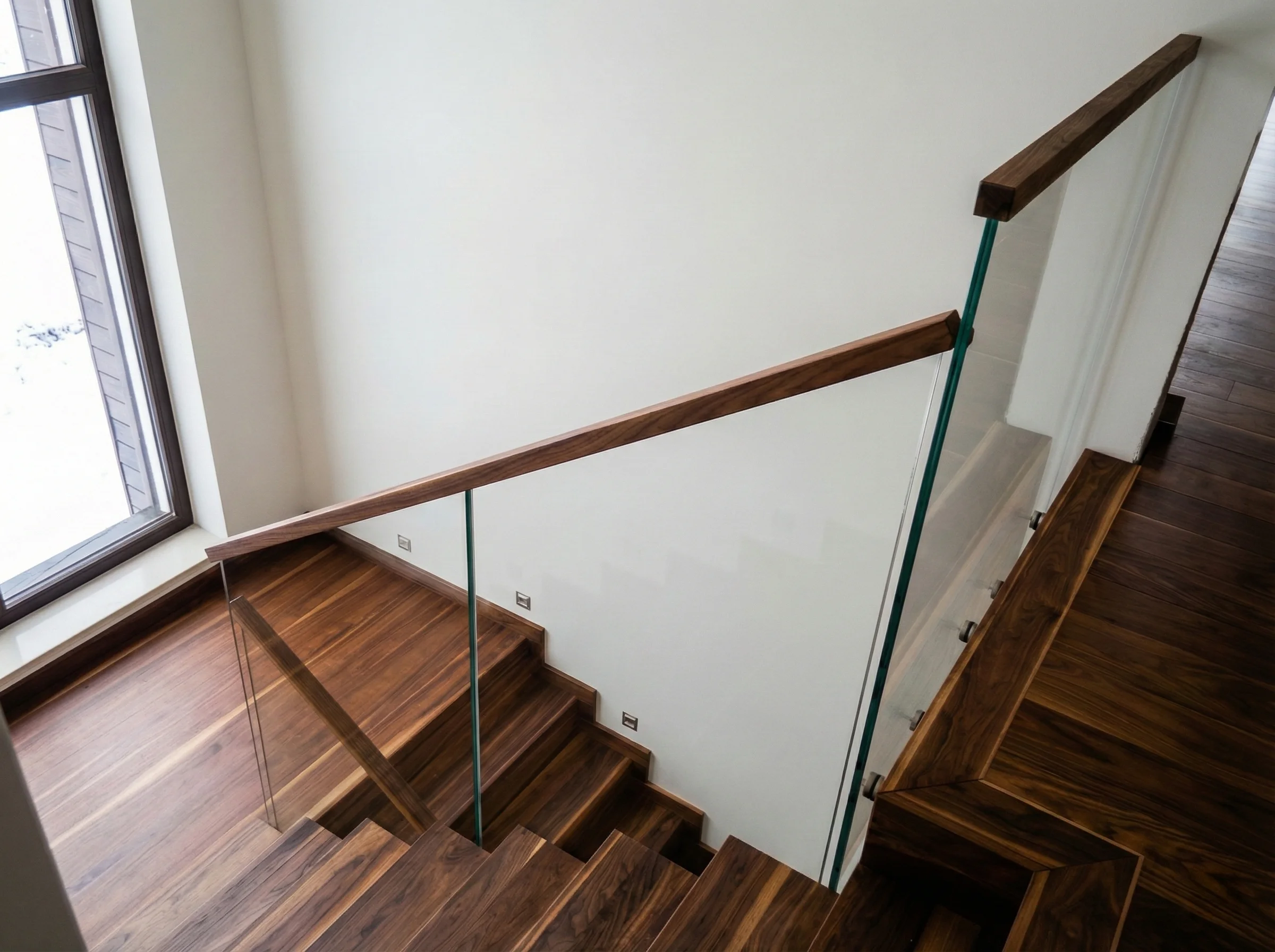 Widok klatki schodowej z góry, efektowna balustrada szklana