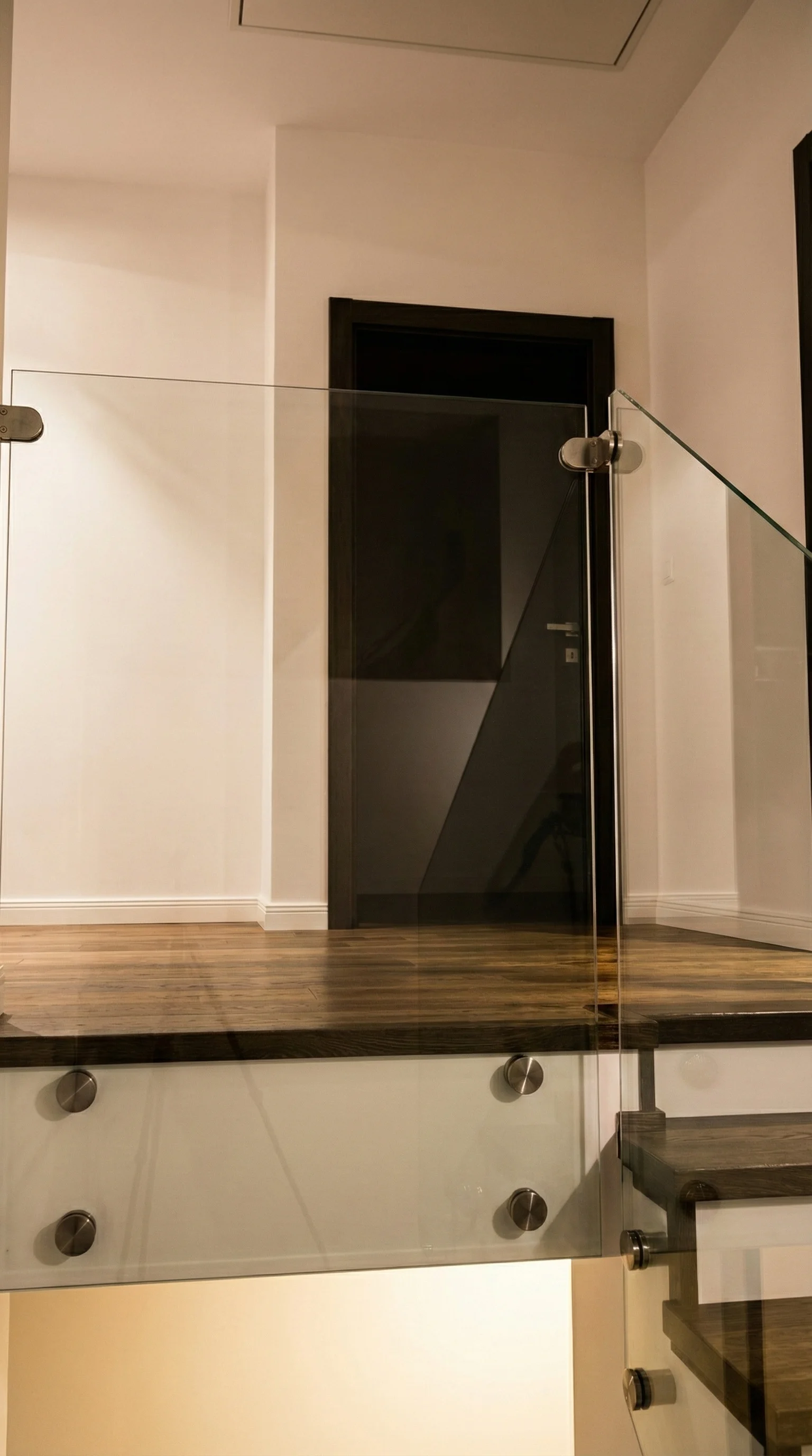 Widok schodów wewnątrz domu, połączenie drewna i szkła