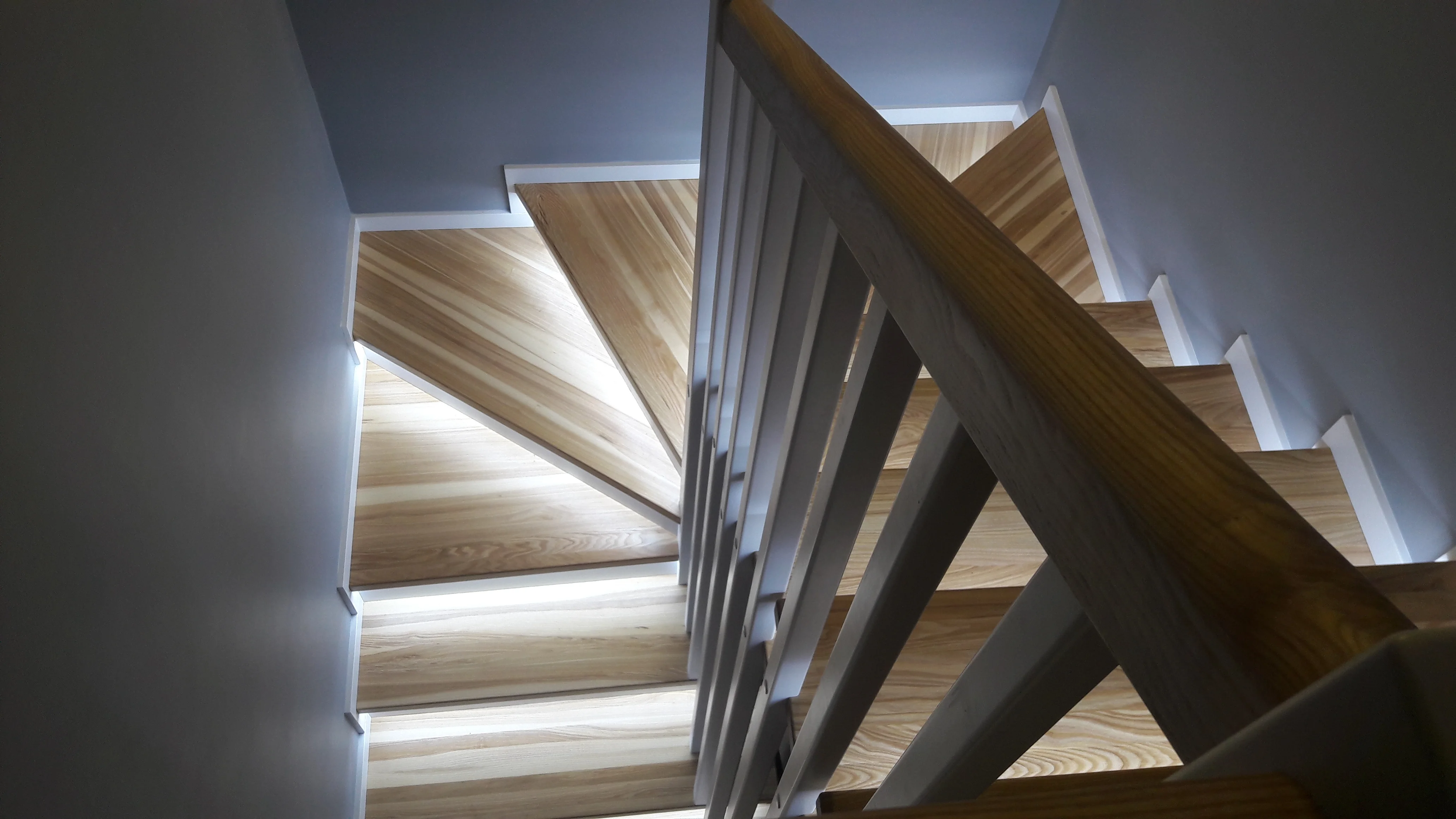 Detal łączenia stopnia jesionowego z białą podstopnicą