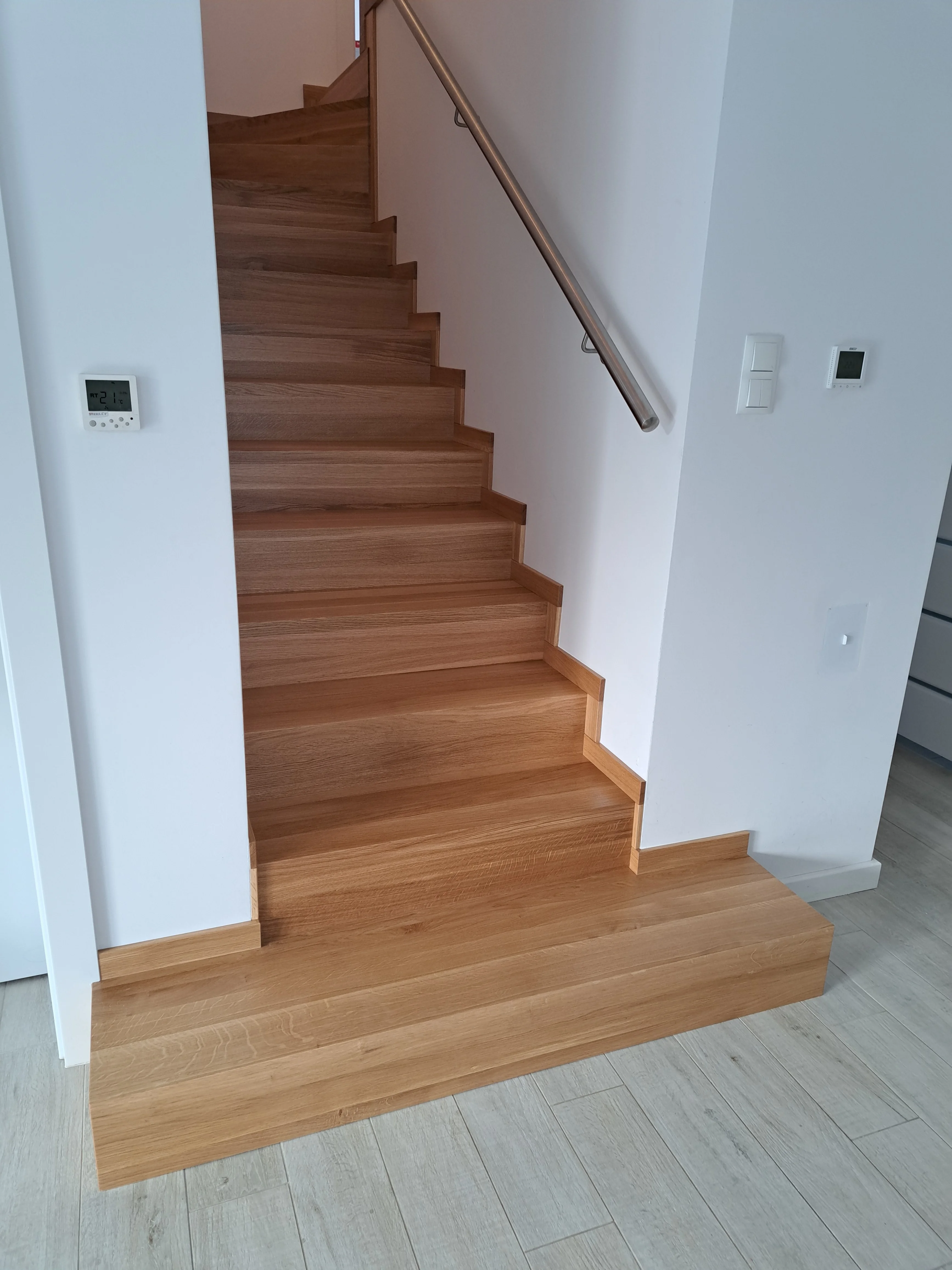 Detal balustrady ze stali nierdzewnej przy schodach dębowych