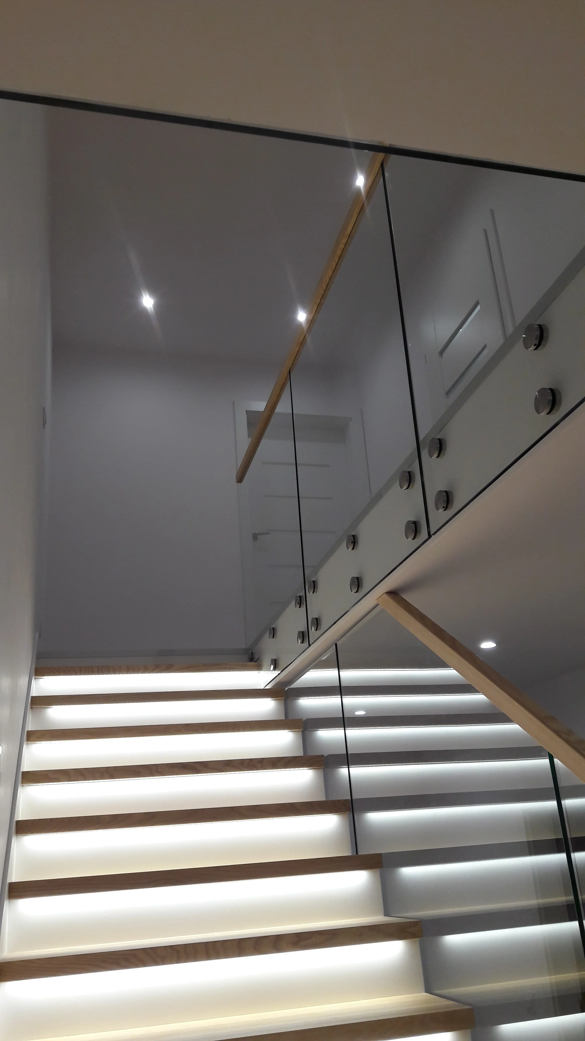 Widok klatki schodowej ze szklaną barierką